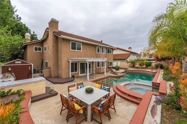 view of swimming pool with a shed, a pergola, a patio area, a fenced backyard, and an in ground hot tub
