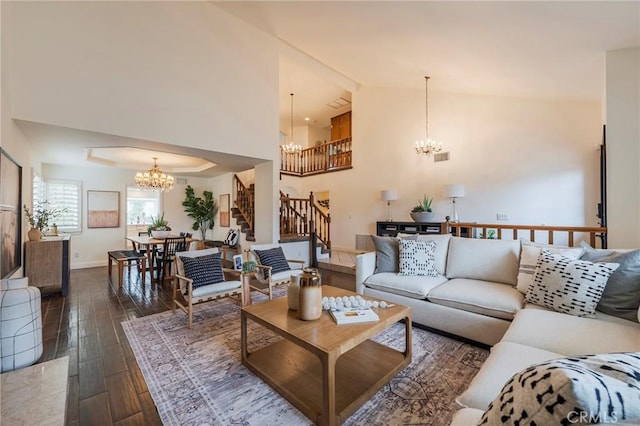 living area featuring baseboards, a notable chandelier, dark wood-style flooring, stairs, and high vaulted ceiling