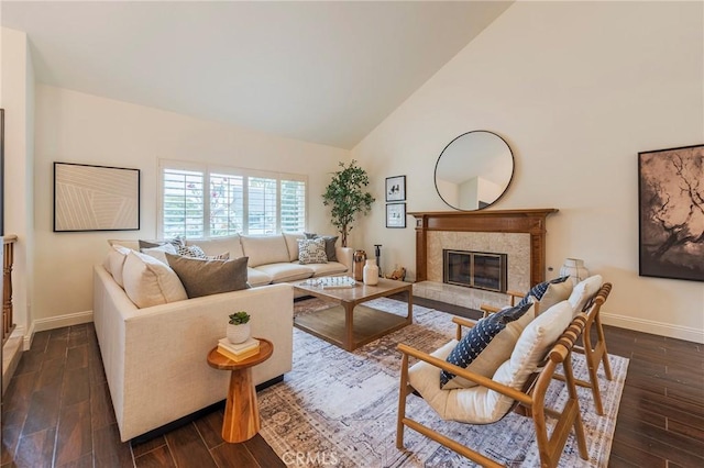 living area featuring high vaulted ceiling, dark wood-type flooring, and baseboards