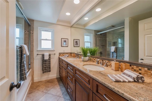 bathroom featuring tile patterned floors, shower / bath combination with glass door, double vanity, and a sink