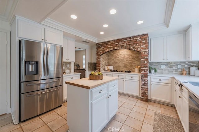 kitchen featuring backsplash, white cabinetry, light tile patterned floors, and stainless steel appliances