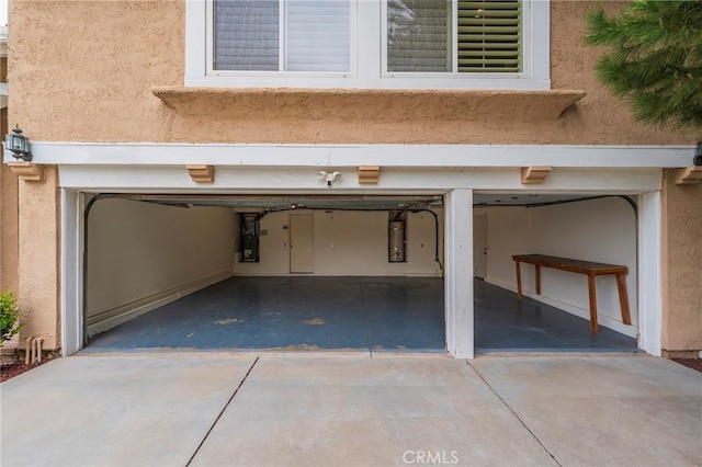 garage featuring strapped water heater, driveway, and electric panel
