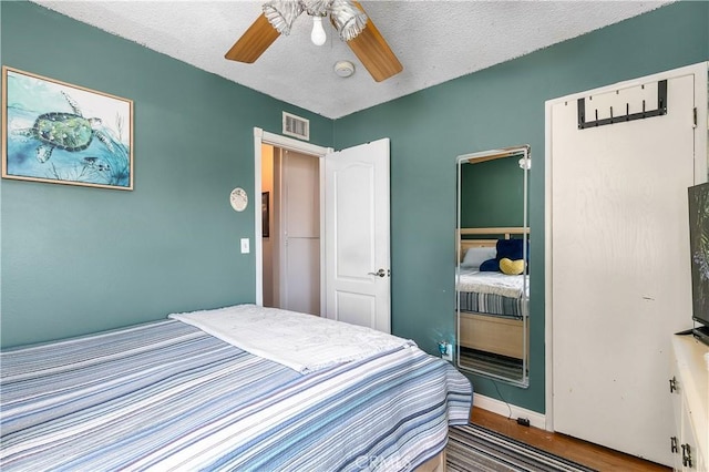 11947 Vivienda Ct, Grand Terrace, CA 92313 - bedroom with visible vents, baseboards, a ceiling fan, a textured ceiling, and wood finished floors