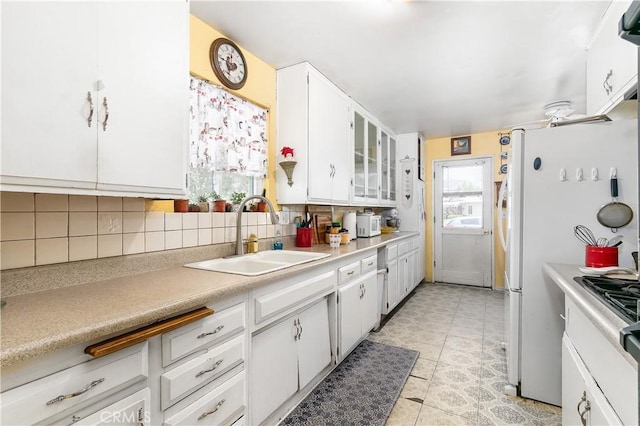 11947 Vivienda Ct, Grand Terrace, CA 92313 - kitchen featuring tasteful backsplash, white cabinets, a sink, light countertops, and freestanding refrigerator