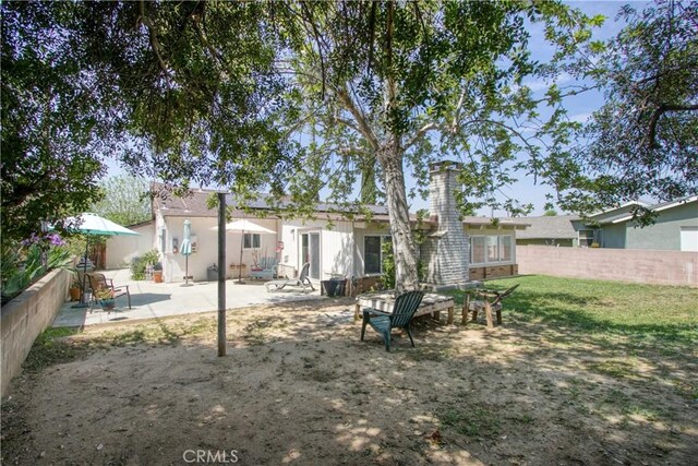 11947 Vivienda Ct, Grand Terrace, CA 92313 - rear view of property featuring fence, a patio, a lawn, and a chimney