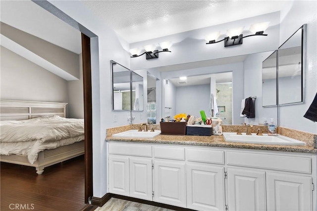 full bath featuring a sink, a shower with shower door, ensuite bath, and wood finished floors