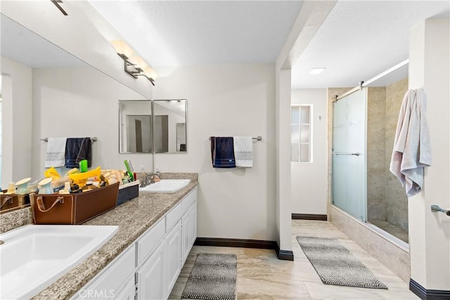 full bathroom with a stall shower, marble finish floor, baseboards, and a sink