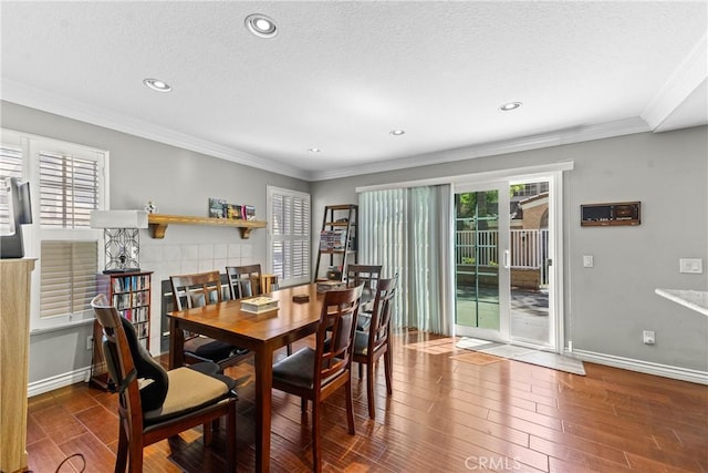 dining space with recessed lighting, a textured ceiling, baseboards, crown molding, and wood finished floors