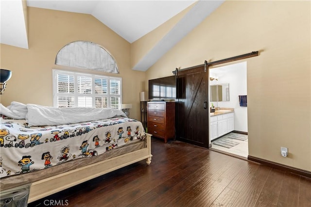 bedroom with a barn door, baseboards, ensuite bathroom, dark wood finished floors, and high vaulted ceiling
