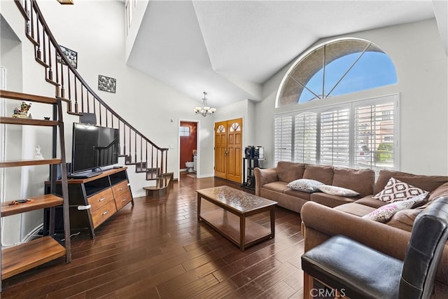 living room with stairway, dark wood finished floors, a chandelier, and high vaulted ceiling