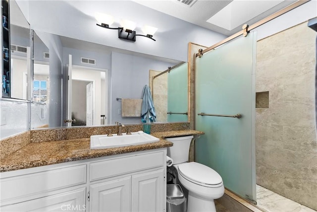 full bath featuring a stall shower, vanity, toilet, and visible vents