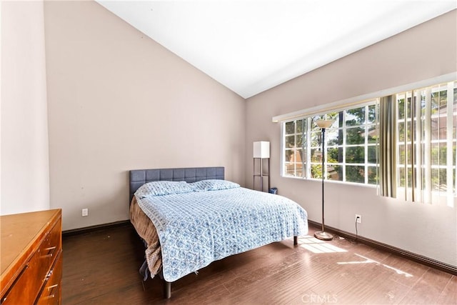 bedroom featuring wood finished floors, vaulted ceiling, and baseboards