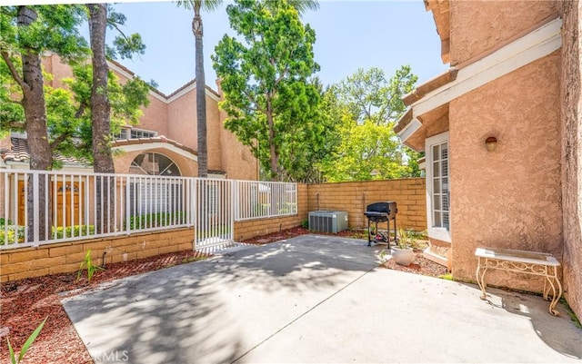 view of patio with fence private yard and central AC