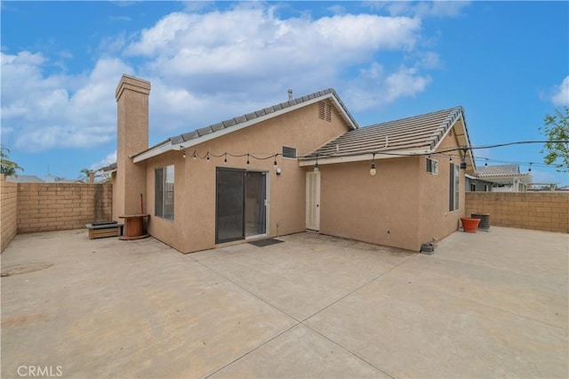 14850 Filly Ln, Fontana, CA 92336 - back of property featuring a patio area, a fenced backyard, a chimney, and stucco siding
