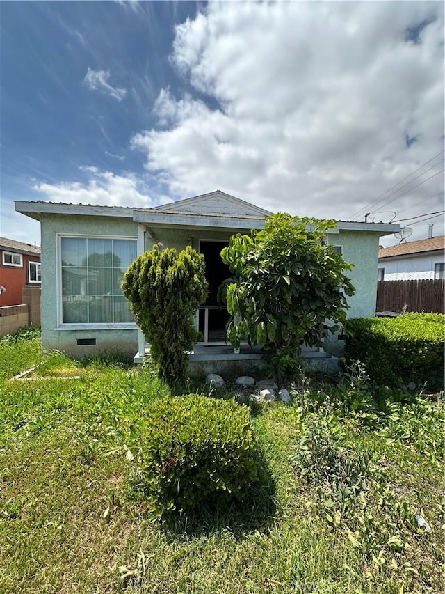 view of front facade featuring fence and stucco siding