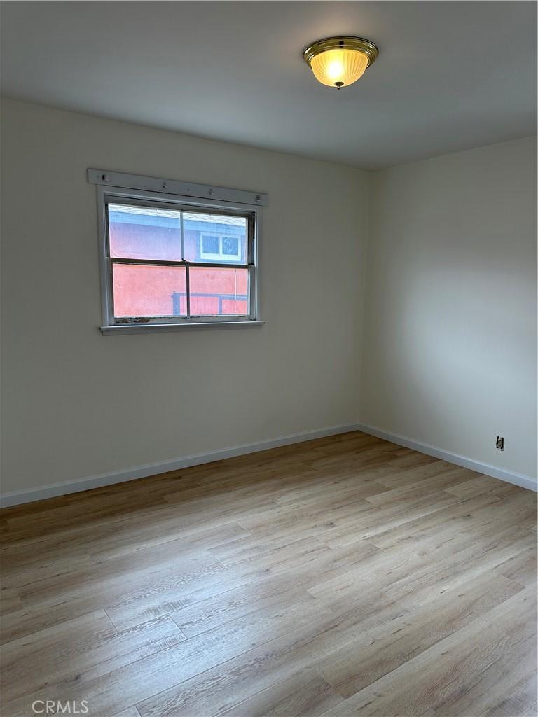 empty room featuring baseboards and wood finished floors