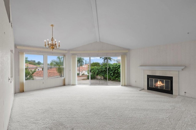 unfurnished living room with an inviting chandelier, a wealth of natural light, a tile fireplace, and vaulted ceiling with beams