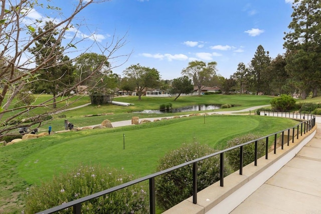 view of home's community featuring golf course view, a yard, and a water view