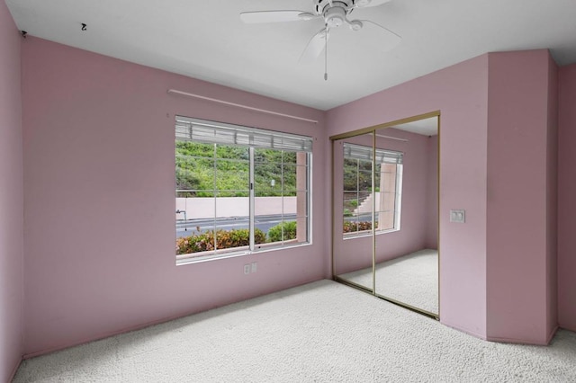unfurnished bedroom featuring a closet, a ceiling fan, and carpet floors