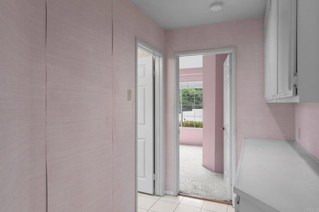 corridor featuring light carpet and light tile patterned floors