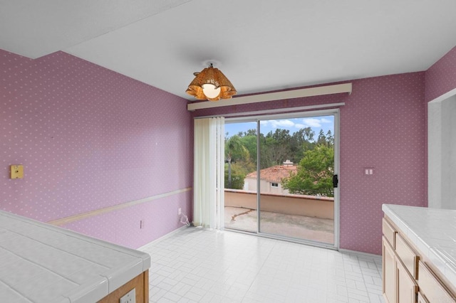 unfurnished dining area with wallpapered walls