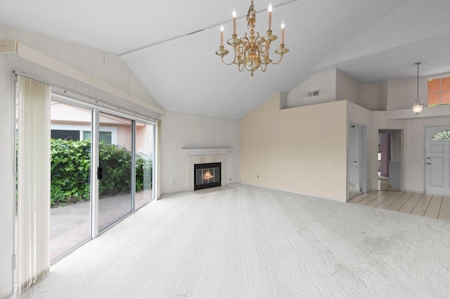 unfurnished living room with a notable chandelier, carpet floors, a fireplace with flush hearth, visible vents, and high vaulted ceiling