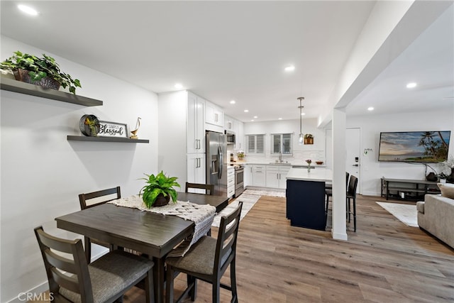 dining space with recessed lighting and light wood-style flooring