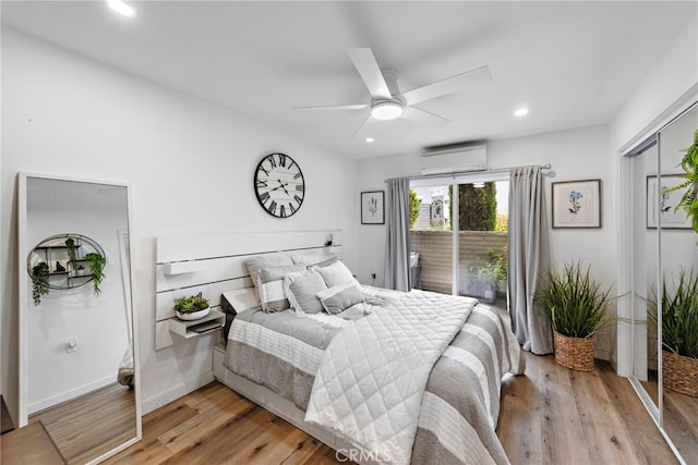 bedroom featuring baseboards, light wood-style floors, ceiling fan, recessed lighting, and a wall unit AC