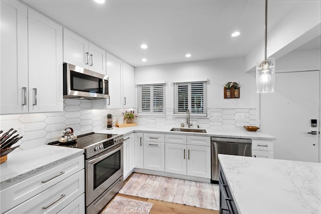 kitchen with a sink, backsplash, stainless steel appliances, and recessed lighting