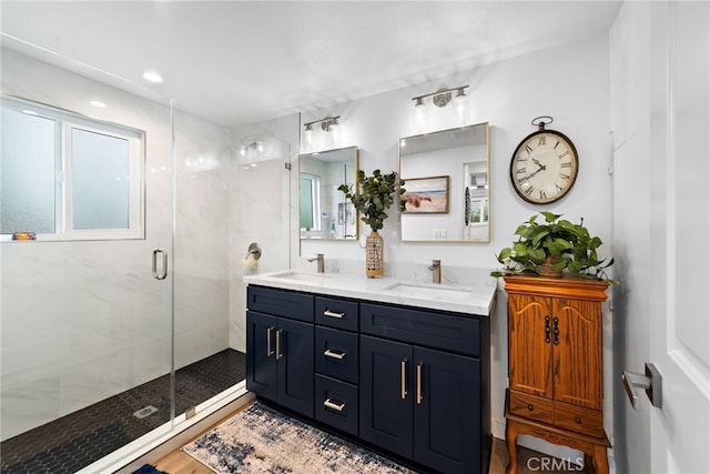 bathroom featuring double vanity, a shower stall, and a sink