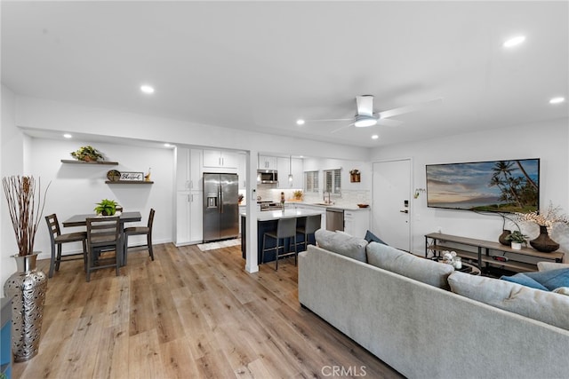 living area featuring recessed lighting, a ceiling fan, and light wood-type flooring