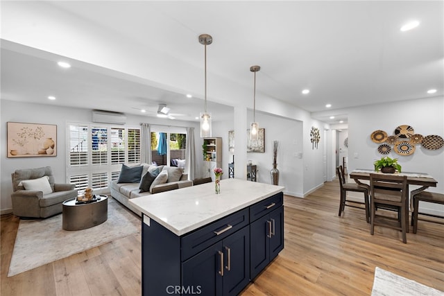 kitchen featuring light wood-style floors, recessed lighting, an AC wall unit, and decorative light fixtures