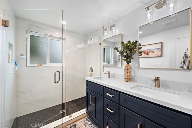 full bathroom with a sink, a shower stall, and double vanity