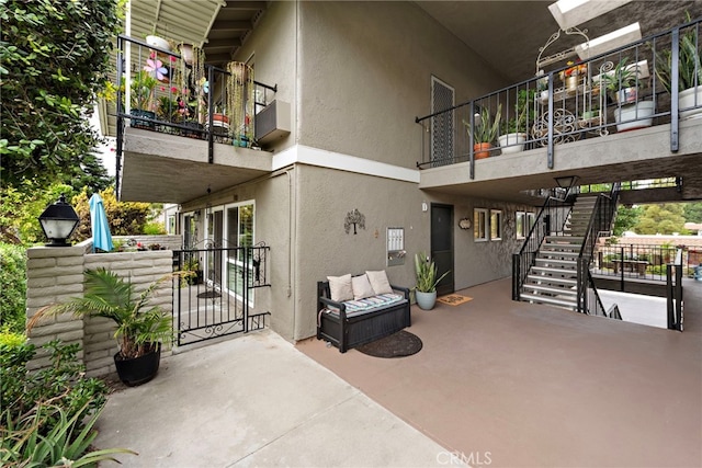 exterior space with stairs, a gate, and a balcony