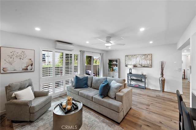 living area with a wall unit AC, recessed lighting, and light wood-style flooring