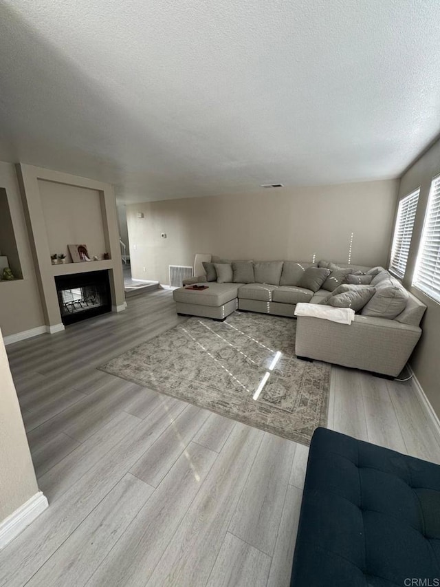 40037 White Leaf Ln, Murrieta, CA 92562 - living area featuring a textured ceiling, wood finished floors, baseboards, and visible vents