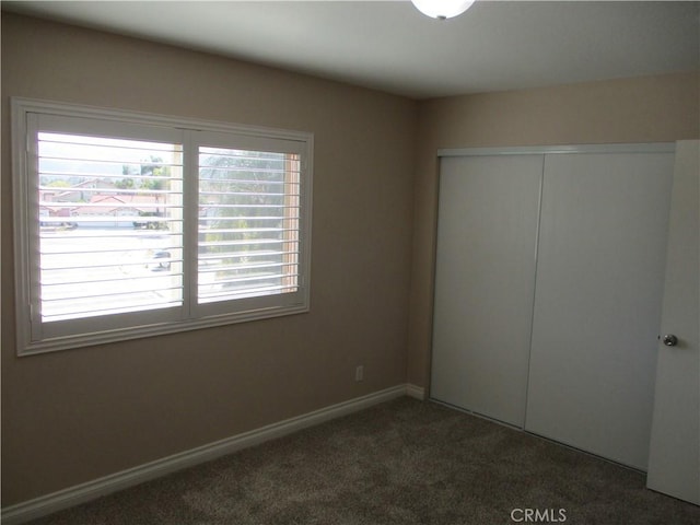22956 Akwo Cir, Wildomar, CA 92595 - unfurnished bedroom featuring a closet, dark carpet, and baseboards