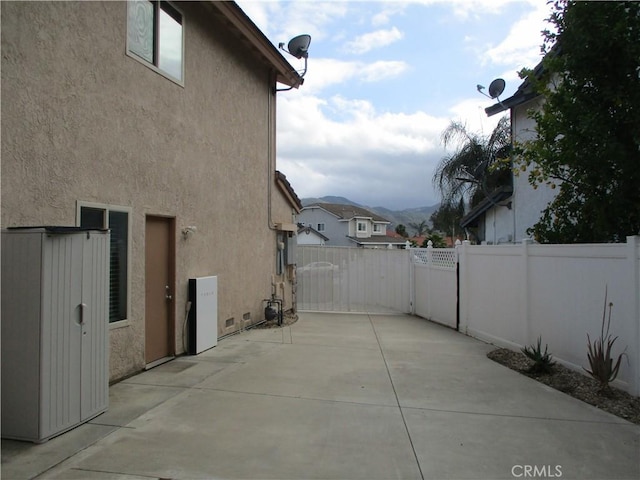 22956 Akwo Cir, Wildomar, CA 92595 - view of side of home with a fenced backyard, stucco siding, and a patio