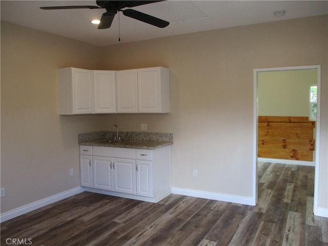22956 Akwo Cir, Wildomar, CA 92595 - kitchen with dark wood finished floors, white cabinetry, ceiling fan, and light stone counters