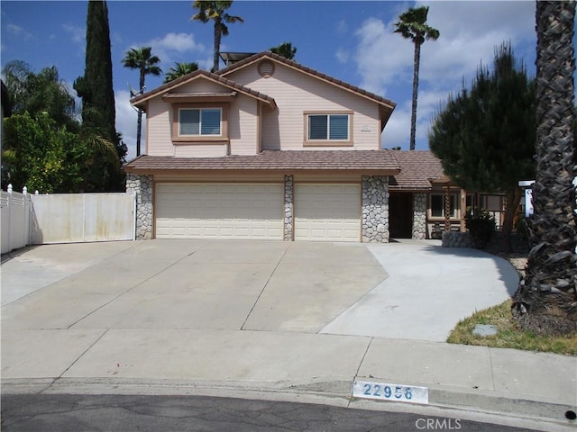 22956 Akwo Cir, Wildomar, CA 92595 - traditional-style home with stone siding, an attached garage, concrete driveway, and fence