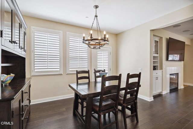 dining room with baseboards, dark wood-type flooring, and a chandelier