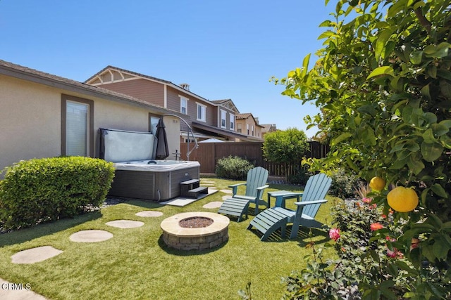 view of yard with cooling unit, a hot tub, fence, and an outdoor fire pit
