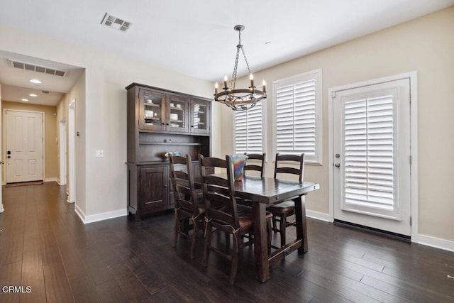 dining space with an inviting chandelier, baseboards, dark wood-style floors, and visible vents