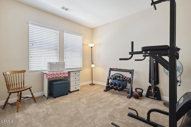 workout area with baseboards, plenty of natural light, light colored carpet, and visible vents