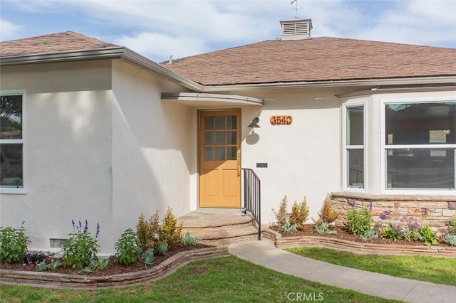 3540 S Sycamore Ave, Los Angeles, CA 90016 - view of exterior entry with a chimney, stucco siding, and roof with shingles
