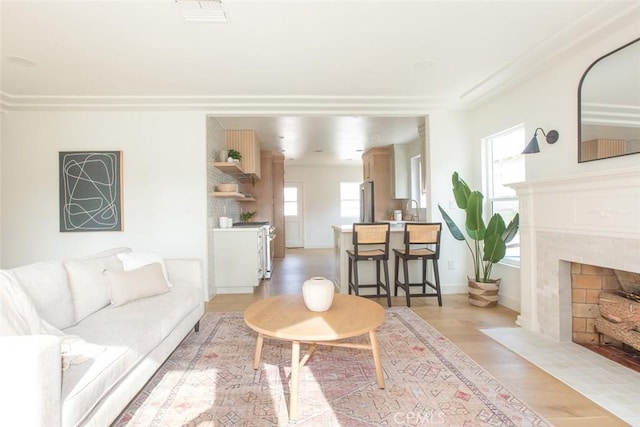 3540 S Sycamore Ave, Los Angeles, CA 90016 - living room with a high end fireplace, light wood finished floors, and visible vents