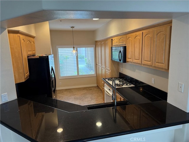 kitchen featuring light colored carpet, hanging light fixtures, a sink, baseboards, and black appliances