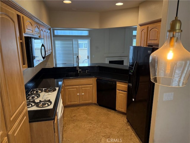 kitchen with dark countertops, a sink, black appliances, a peninsula, and recessed lighting