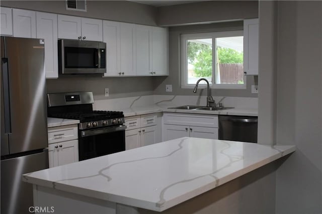 26231 Pine Valley Rd, Menifee, CA 92586 - kitchen featuring appliances with stainless steel finishes, a sink, white cabinets, and light stone counters