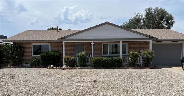 26231 Pine Valley Rd, Menifee, CA 92586 - ranch-style home featuring a garage, brick siding, covered porch, concrete driveway, and roof with shingles